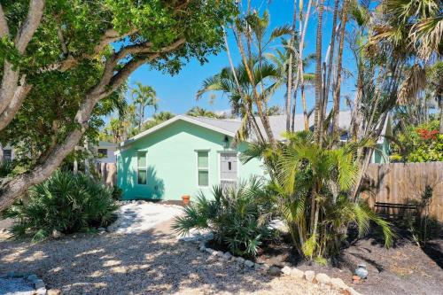 a house with palm trees in front of it at Tipsy Turtle in Sanibel