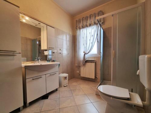 a bathroom with a sink and a toilet and a window at Bruno's Rooms in Bašanija
