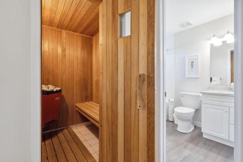 La salle de bains est pourvue de toilettes et d'un mur en bois. dans l'établissement Wintergreen 2 min Village Sauna, à Blue Mountains