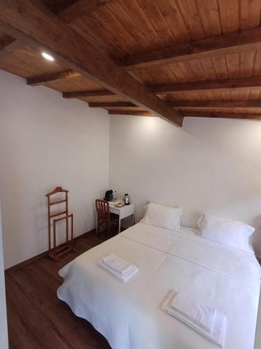 a bedroom with a white bed with a wooden ceiling at Boa Ventura Home in Porto