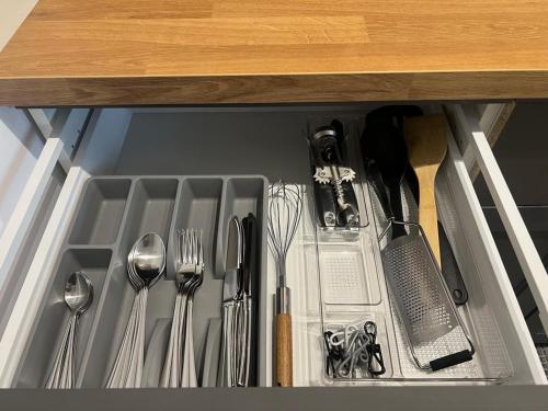 a drawer with utensils and utensils at Zamojska Residence Silver Leaf Apartment in Lublin