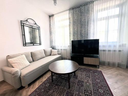 a living room with a couch and a tv at Zamojska Residence Silver Leaf Apartment in Lublin