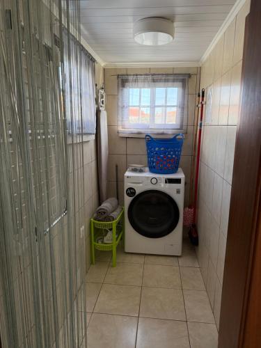 a small bathroom with a washing machine in it at Casa dos Morros in Lajes das Flores