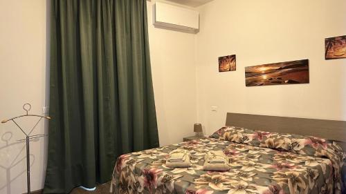 Un dormitorio con una cama y una cortina verde. en Casa Victoria, en Stresa