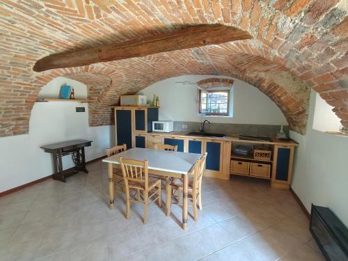 a kitchen with a table and a brick wall at Albaluna 2 casa vacanza in Dronero