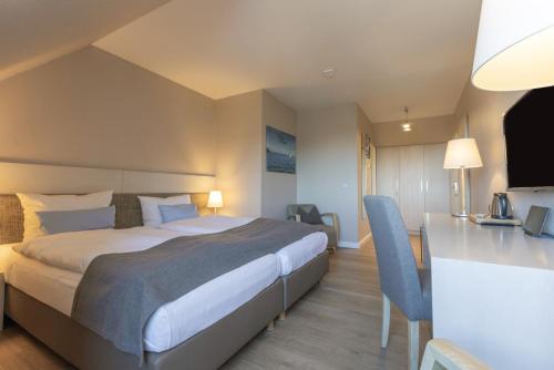 a hotel room with a bed and a desk at Best Western Plus Theodor Storm Hotel in Husum