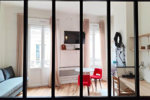 Cette chambre comprend un salon avec une table et un canapé. dans l'établissement Apartments near Basilique Saint-Michel Bordeaux, à Bordeaux