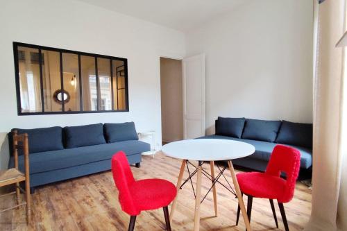 - un salon avec un canapé bleu et des fauteuils rouges dans l'établissement Apartments near Basilique Saint-Michel Bordeaux, à Bordeaux