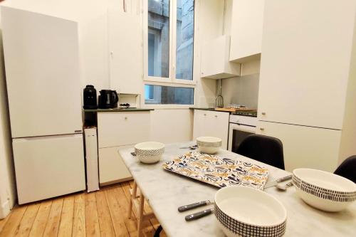 - une cuisine avec une table et des bols dans l'établissement Apartments near Basilique Saint-Michel Bordeaux, à Bordeaux