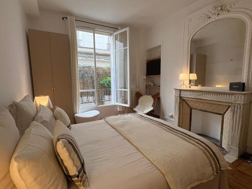 um quarto com uma cama com lareira e um espelho em Comme une maison à deux pas de l'Arc de Triomphe em Paris