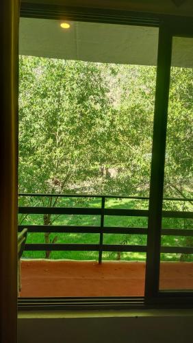 a window in a room with a view of trees at Aangan Residences in Skardu