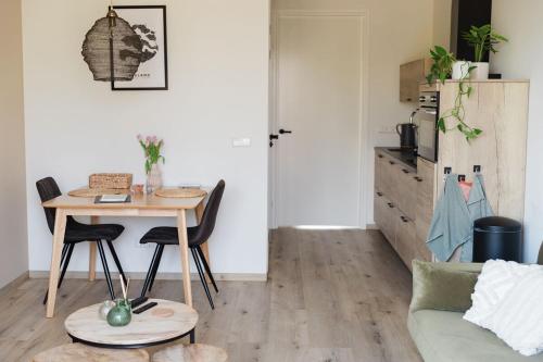 a living room with a table and a couch at De Haas - Tiny house in de Zeeuwse Natuur in Driewegen