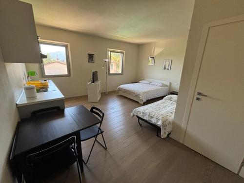 Cette chambre comprend deux lits, un bureau et une table. dans l'établissement Appartamento Via Bandettini, à Lucques