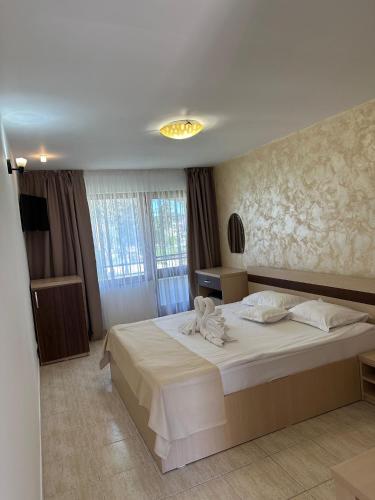 a bedroom with a large bed with white sheets at Hotel Selena Boutique in Neptun
