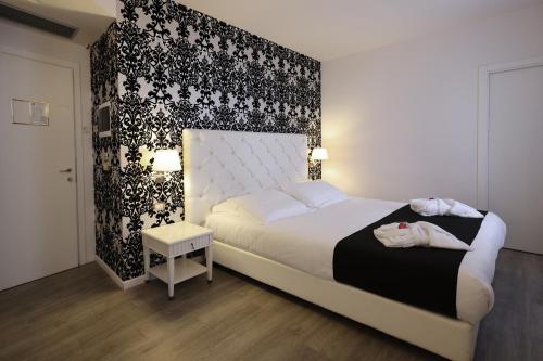 a bedroom with a bed and a black and white wall at Hotel Palazzo Bello - NUOVA GESTIONE in Recanati