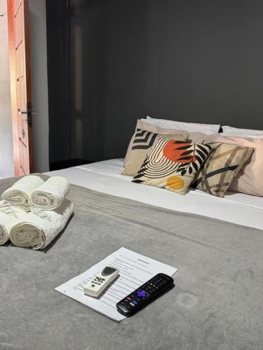a bed with a remote control and a pamphlet on it at BLUE DOOR BRASIL in Abraão