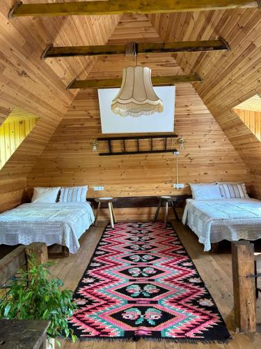 a attic room with two beds and a rug at Breb s Cosy Barn in Breb