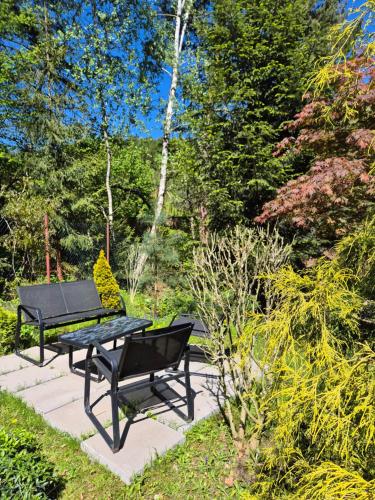 a black picnic table and bench in a garden at Les 6 in Zlín