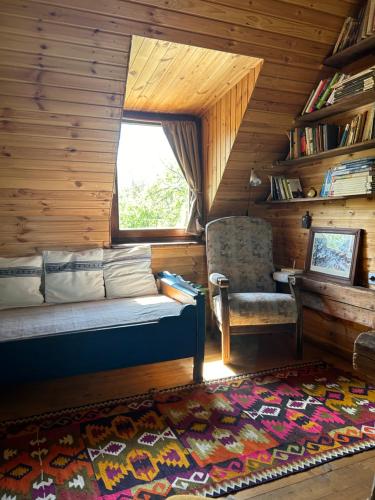 a room with a couch and a chair in a cabin at Breb s Cosy Barn in Breb