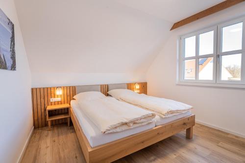 レーメにあるFerienhaus Uhlenhorstのベッドと窓のある白い寝室