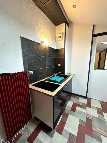 Il comprend une cuisine avec un évier et du carrelage. dans l'établissement Studio cosy gare Épinal, à Épinal