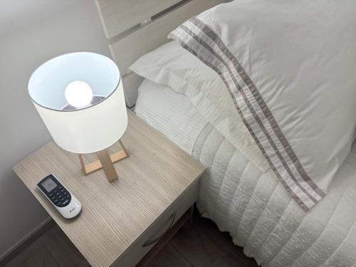 a bed with a night stand with a lamp on it at Apartment Anđelina, Split in Split