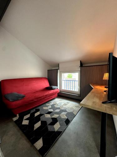 - un salon avec un canapé rouge et une fenêtre dans l'établissement Studio cosy gare Épinal, à Épinal