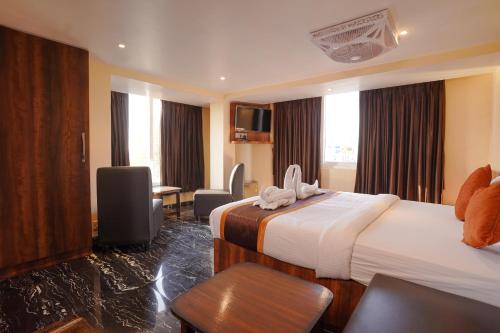 a hotel room with two beds and a desk at SHELDON RESORT & SPA in Phalta