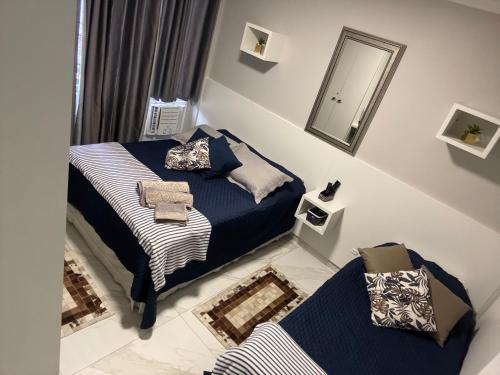 a small bedroom with two beds and a mirror at Apto 1 dorm - San Francisco - localização perfeita in Balneário Camboriú