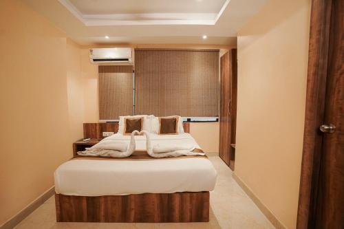 a bedroom with a bed with white sheets at SHELDON RESORT & SPA in Phalta