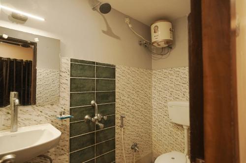 a bathroom with a sink and a toilet and a shower at SHELDON RESORT & SPA in Phalta