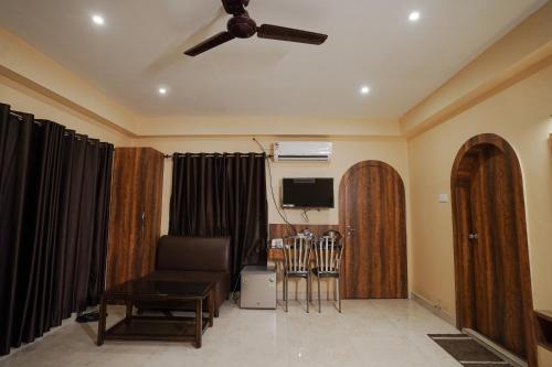 a living room with a ceiling fan and a couch at SHELDON RESORT & SPA in Phalta