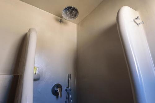 a bathroom with a shower and a toilet in a room at Tataki Family Hotel in Fira