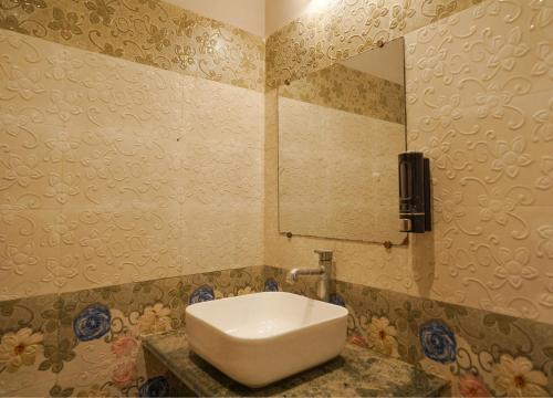 a bathroom with a white sink and a mirror at SHELDON RESORT & SPA in Phalta