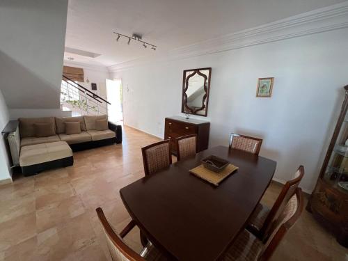 a living room with a table and chairs and a couch at Duplex Monastir avec terrasse sur la marina in Monastir