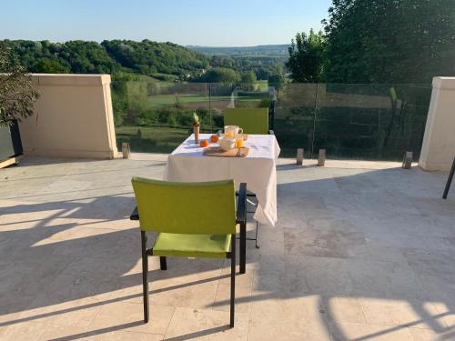 a table with green chairs sitting on a patio at Château du Mont de Guny in Guny