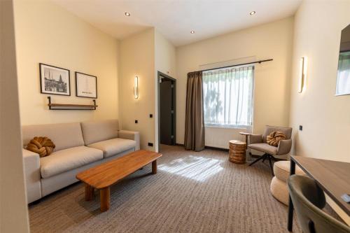a living room with a couch and a table at Flonk Hotel Groningen Centre, BW Signature Collection in Groningen