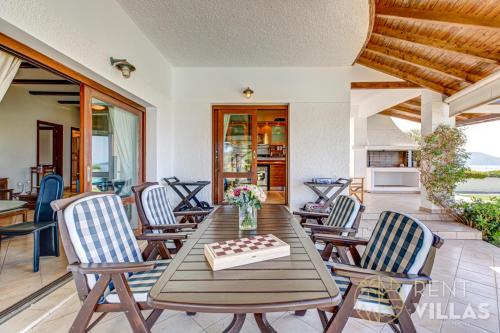 a dining room with a table and chairs at Beachfront Villa Armonia in Porto Hydra by goutos properties in Ermioni