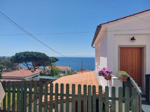 a white house with a fence and a view of the ocean at Casa Guerrino in Chiessi