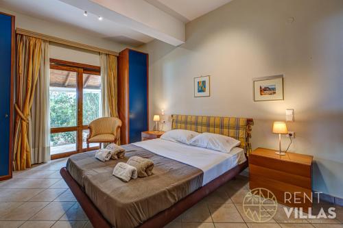 a bedroom with a bed with towels on it at Beachfront Villa Armonia in Porto Hydra by goutos properties in Ermioni