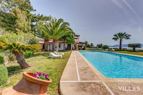 a villa with a swimming pool and palm trees at Beachfront Villa Armonia in Porto Hydra by goutos properties in Ermioni