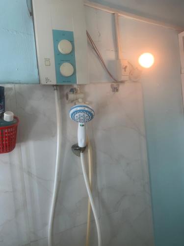 a shower with a hose in the corner of a bathroom at Private Rooms-Low Price- Suburban of Saigon in Ho Chi Minh City