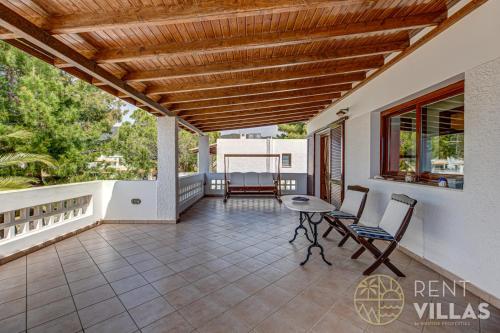 a patio with a table and chairs on a balcony at Beachfront Villa Armonia in Porto Hydra by goutos properties in Ermioni