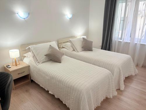a bedroom with two beds with white sheets and a window at Apartment Anđelina, Split in Split