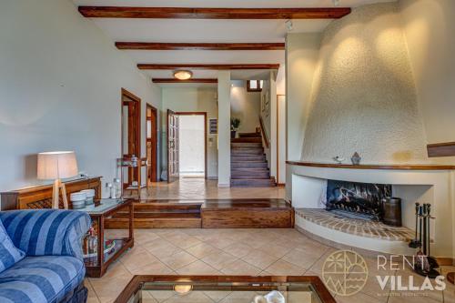 a living room with a blue couch and a fireplace at Beachfront Villa Armonia in Porto Hydra by goutos properties in Ermioni