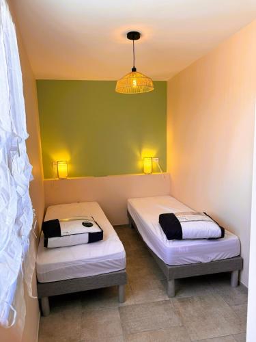 - 2 lits dans une chambre dotée d'un mur vert dans l'établissement Hébergement de Standing à la Mer avec bel extérieur, à Banyuls-sur-Mer