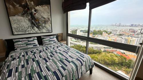a bedroom with a bed and two large windows at Unixx South Pattaya by ladda in Pattaya South