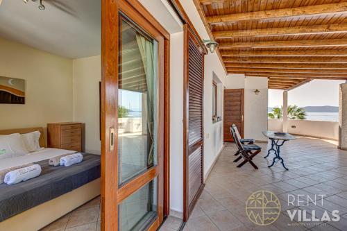 a bedroom with a bed and a view of the ocean at Beachfront Villa Armonia in Porto Hydra by goutos properties in Ermioni