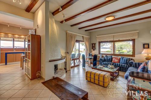 a living room with a couch and a fireplace at Beachfront Villa Armonia in Porto Hydra by goutos properties in Ermioni
