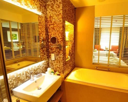 a bathroom with a tub and a sink and a bath tub at The Cocoon Boutique Hotel in Manila